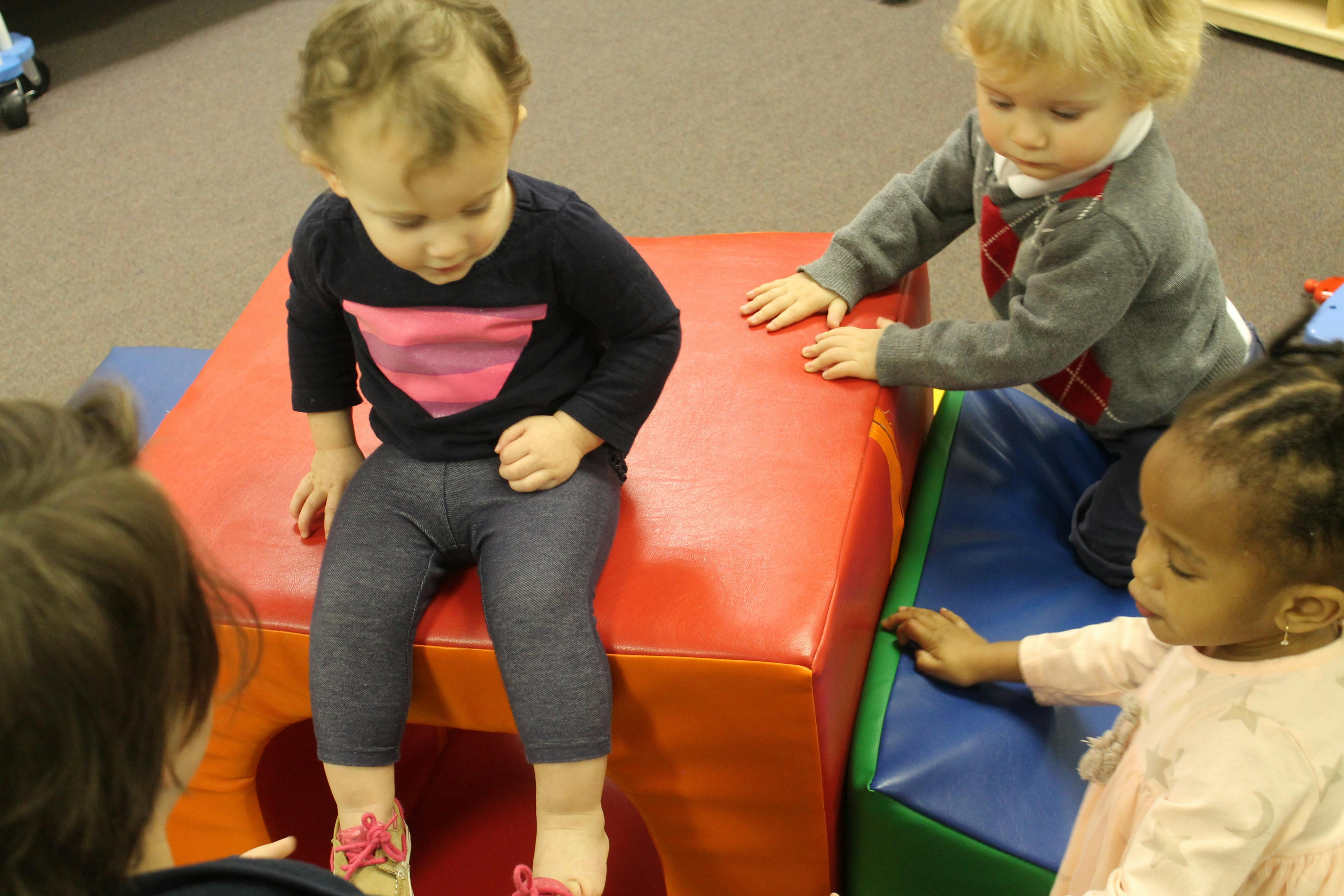 Three children playing with soft blocks