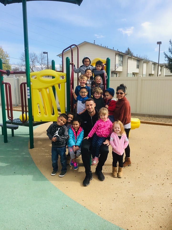 Group of adults and children on a playground structure