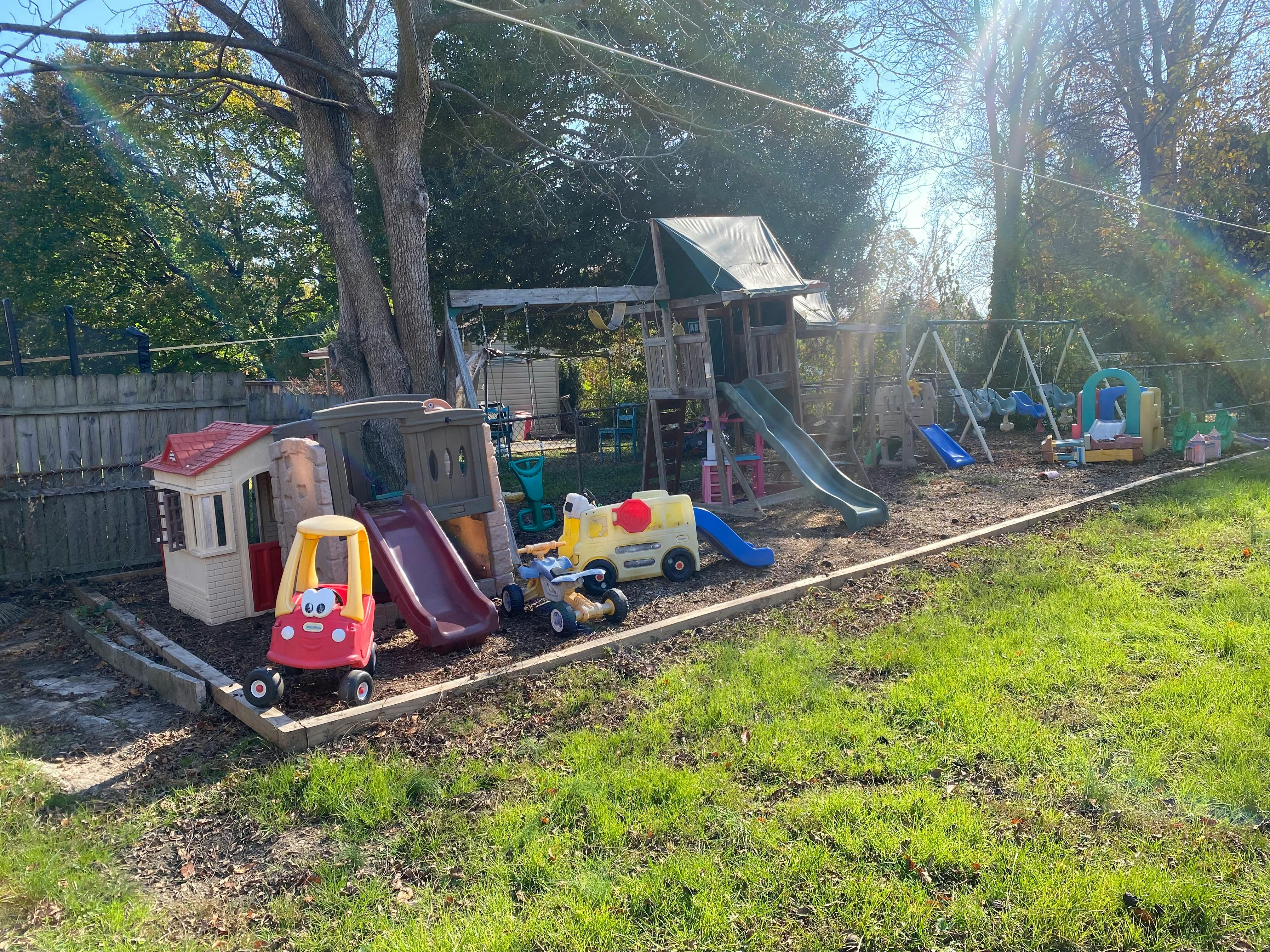Outdoor playground with slides, swings, and toy cars