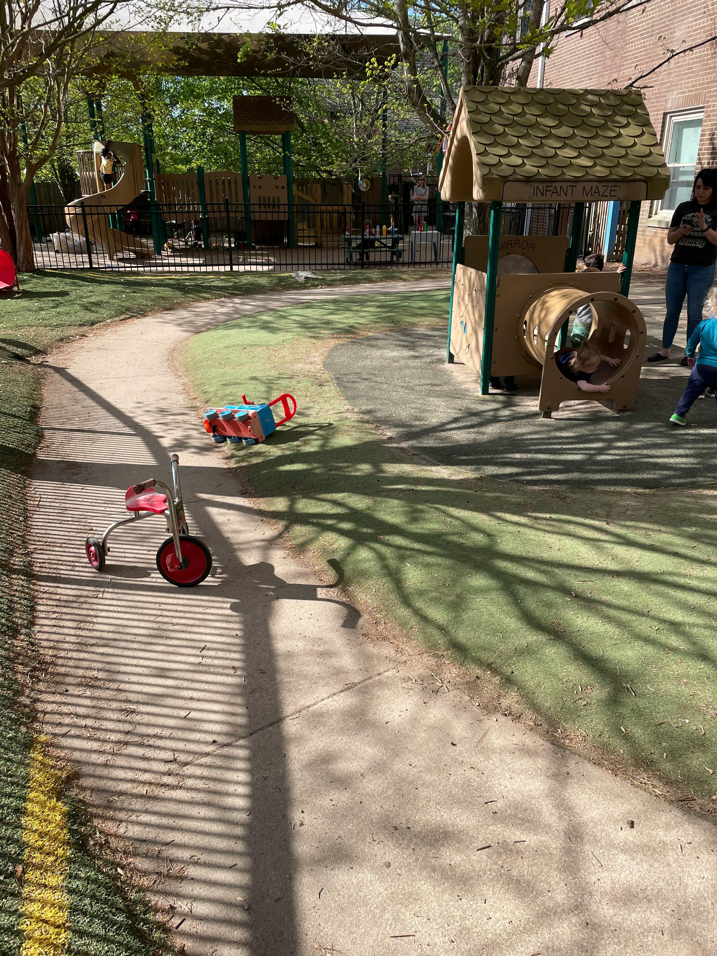Tricycle and toy wagon on a path in a playground
