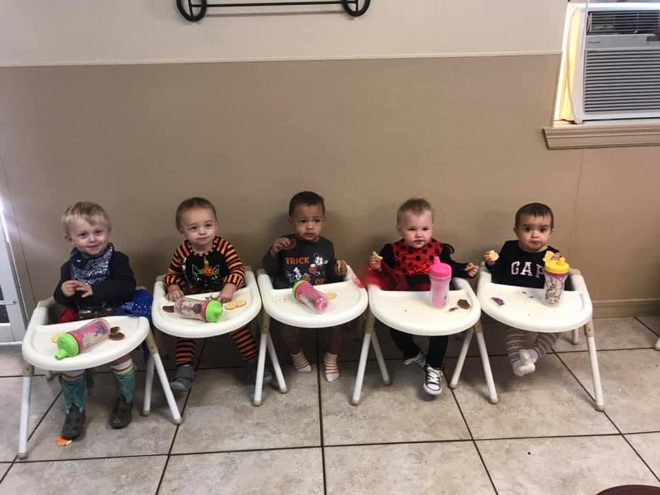 Five children sitting in high chairs