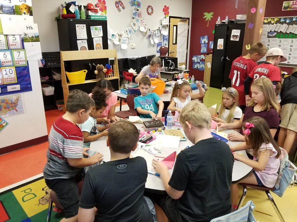 Children gathered around tables in a classroom