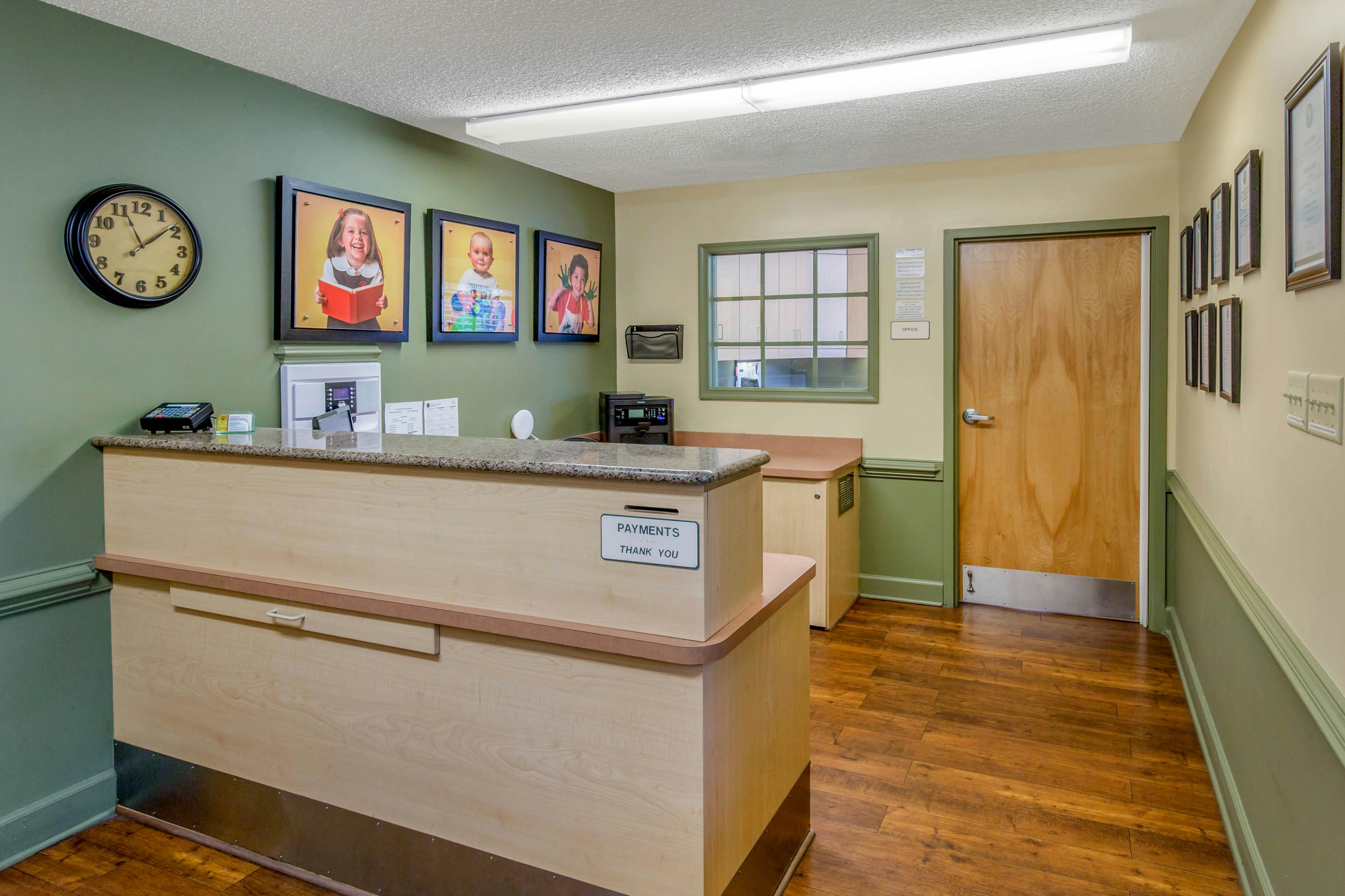 Reception desk with payments sign and pictures of children on the wall