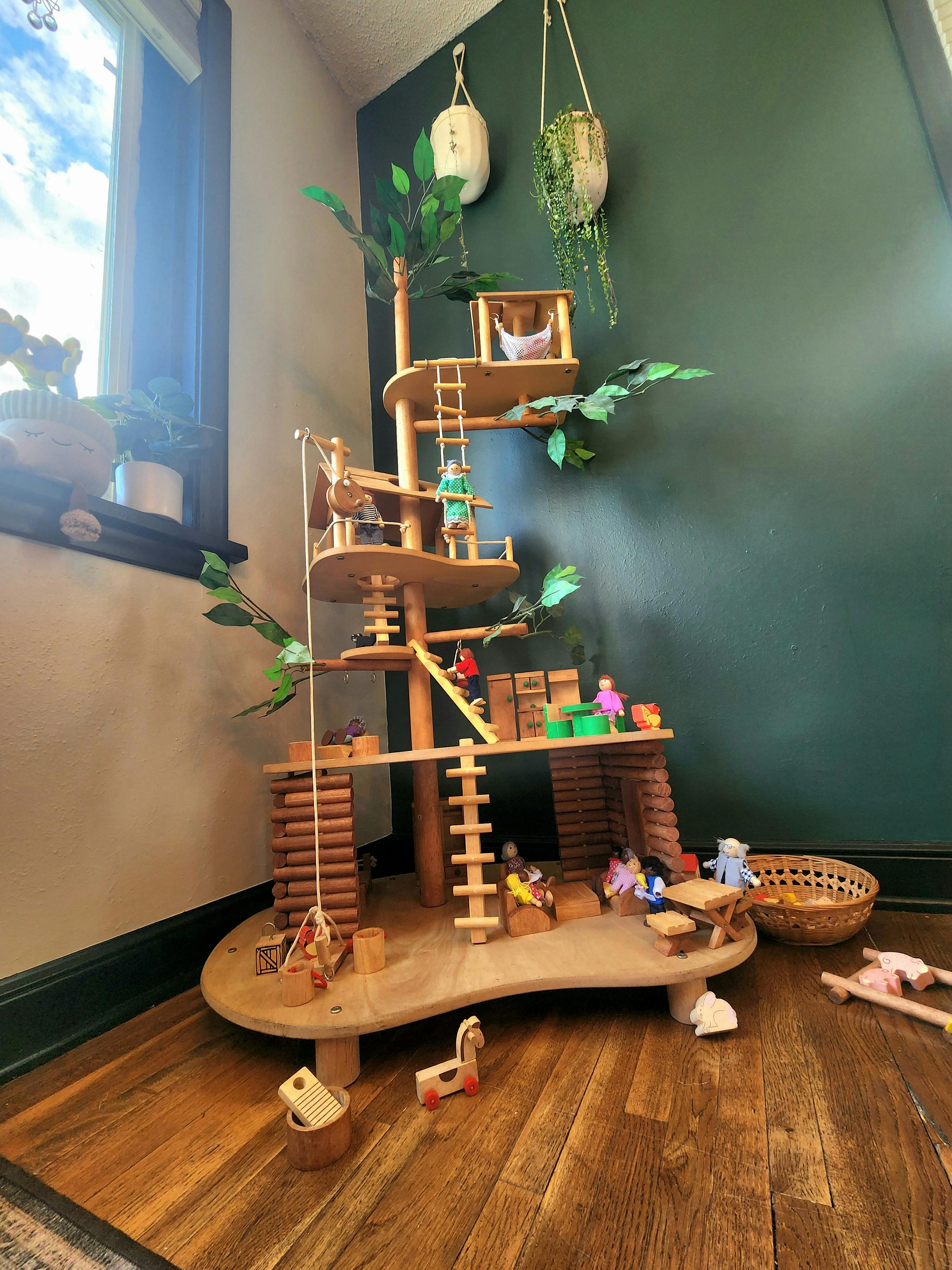 Wooden multi-level treehouse toy with small figures and accessories