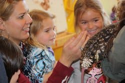Adult and two children looking at a bird