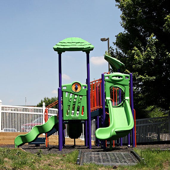 Green and purple playground structure with slides