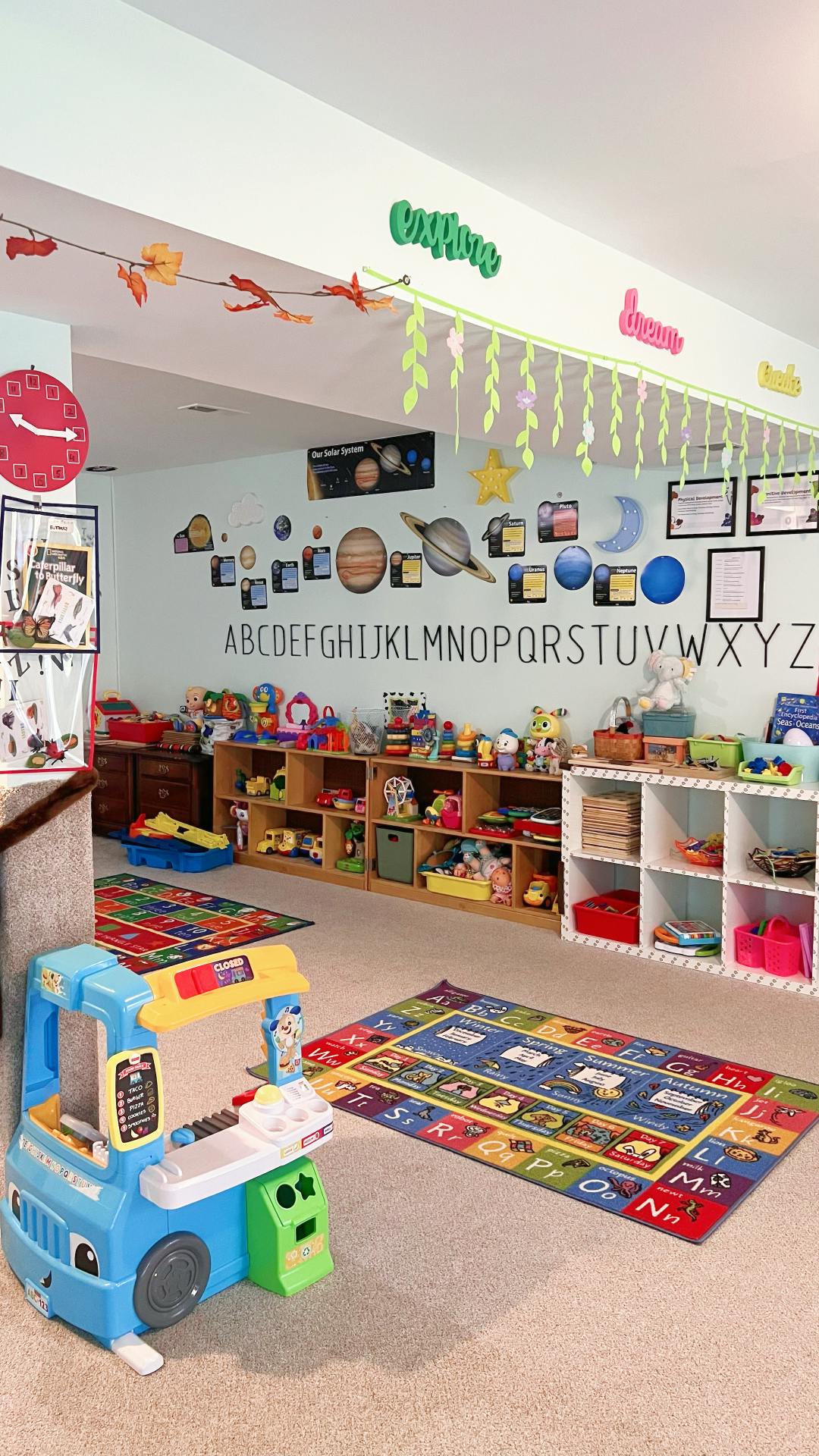 Playroom with alphabet rug, toy shelves, and wall decorations