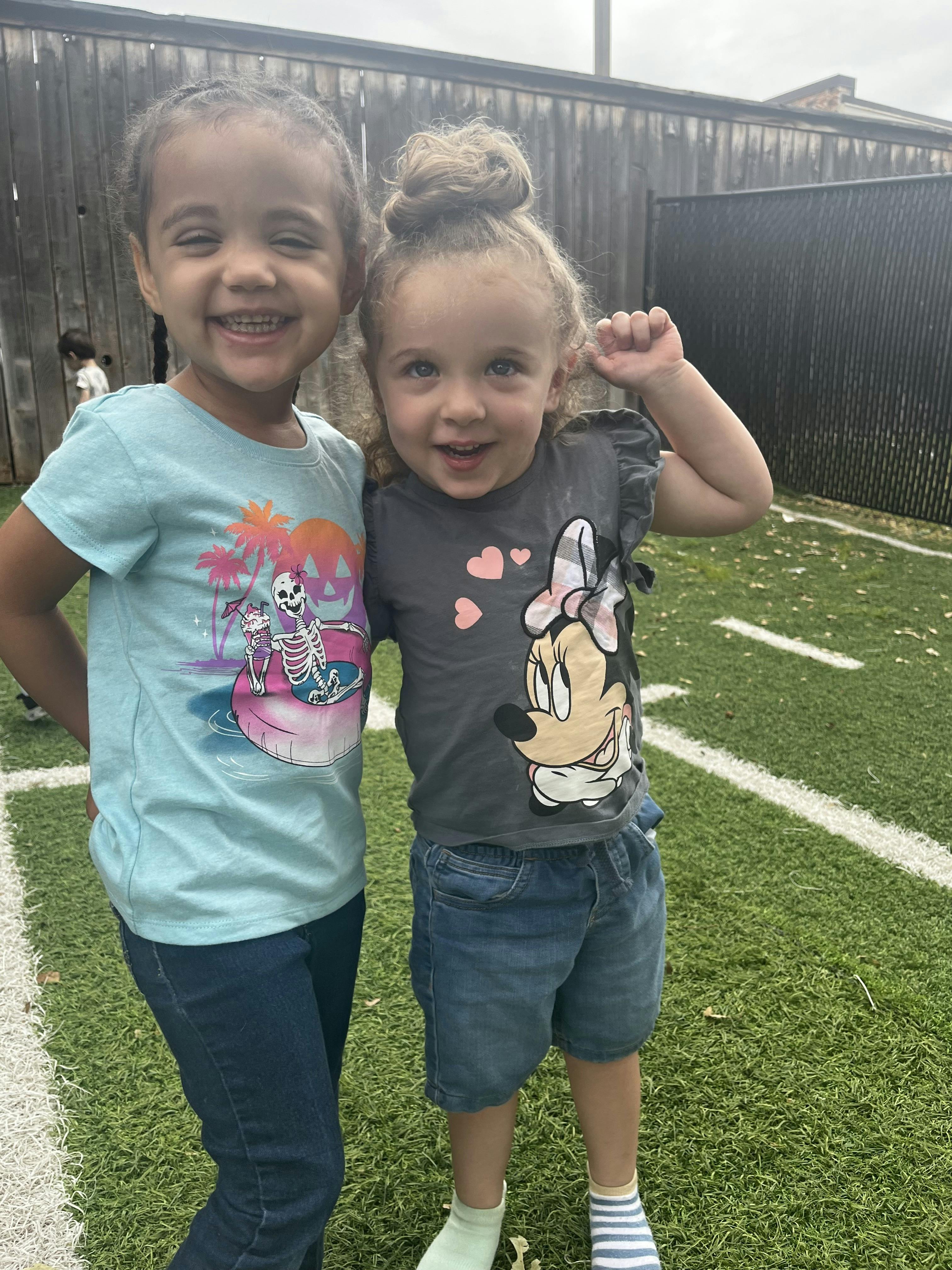 Two children standing on artificial grass