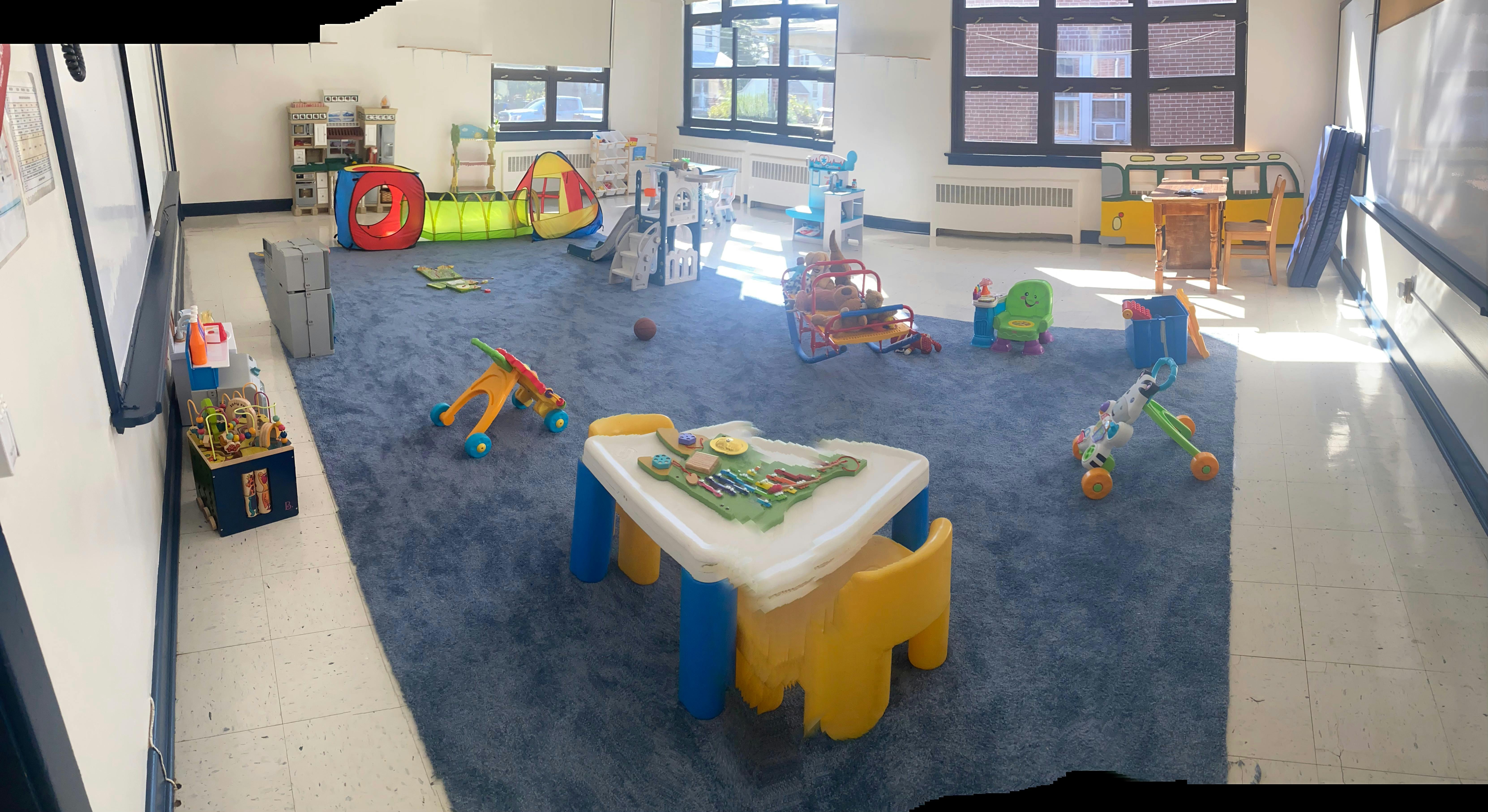 Playroom with blue carpet and various toys