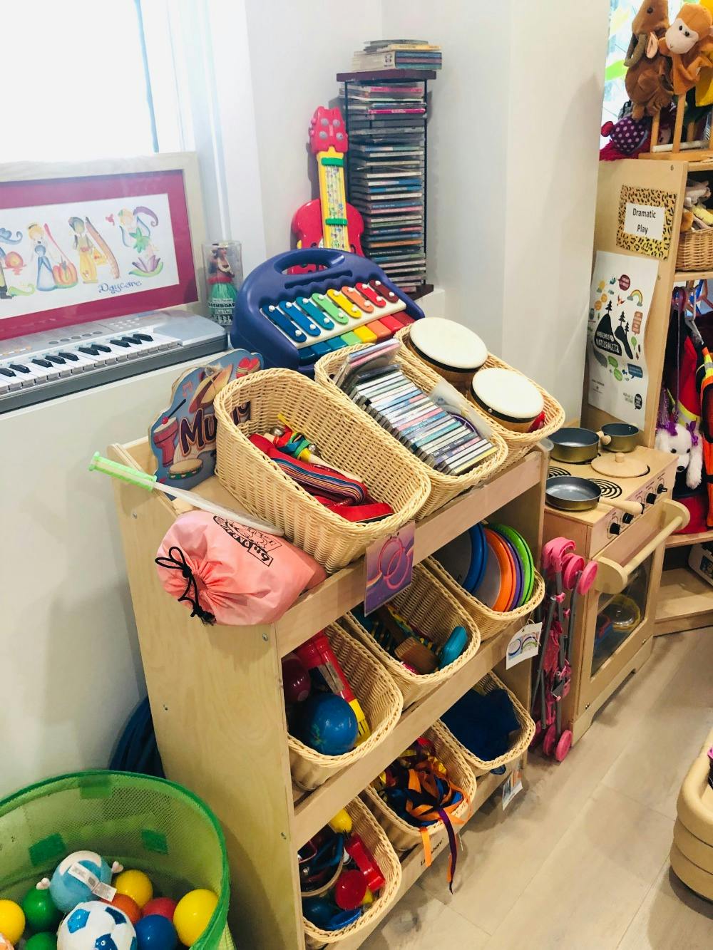 Toy storage unit with baskets of toys, a keyboard, and a toy piano