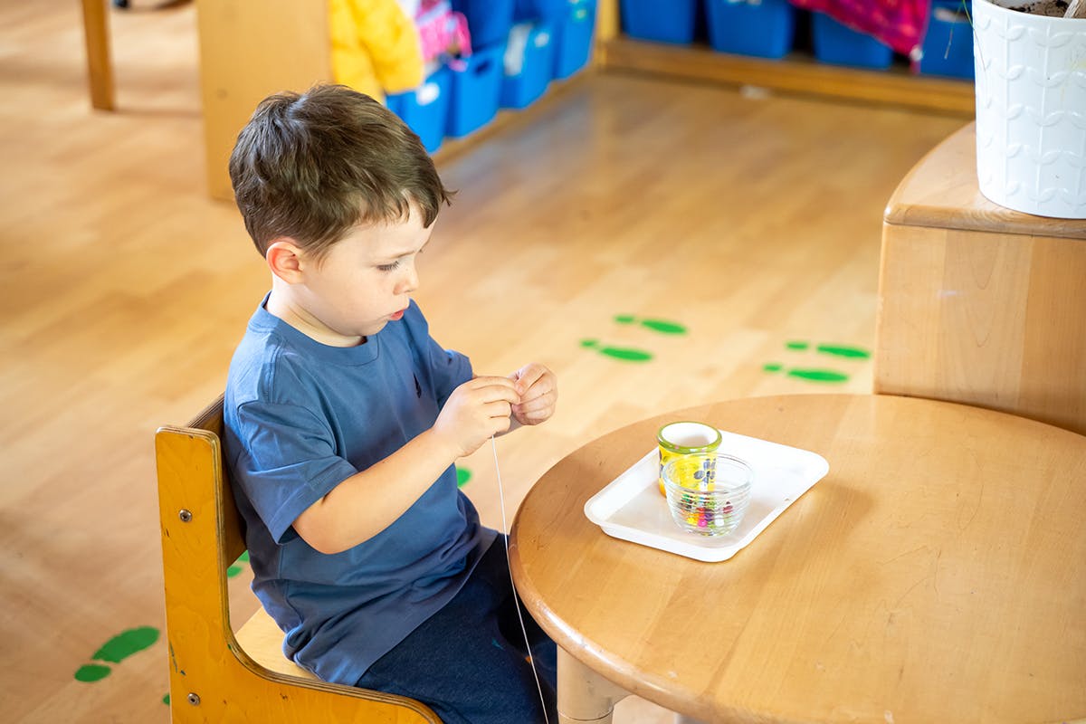 Child sitting at a table, looking at something in their hands
