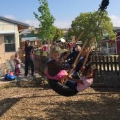 Two children on a tire swing