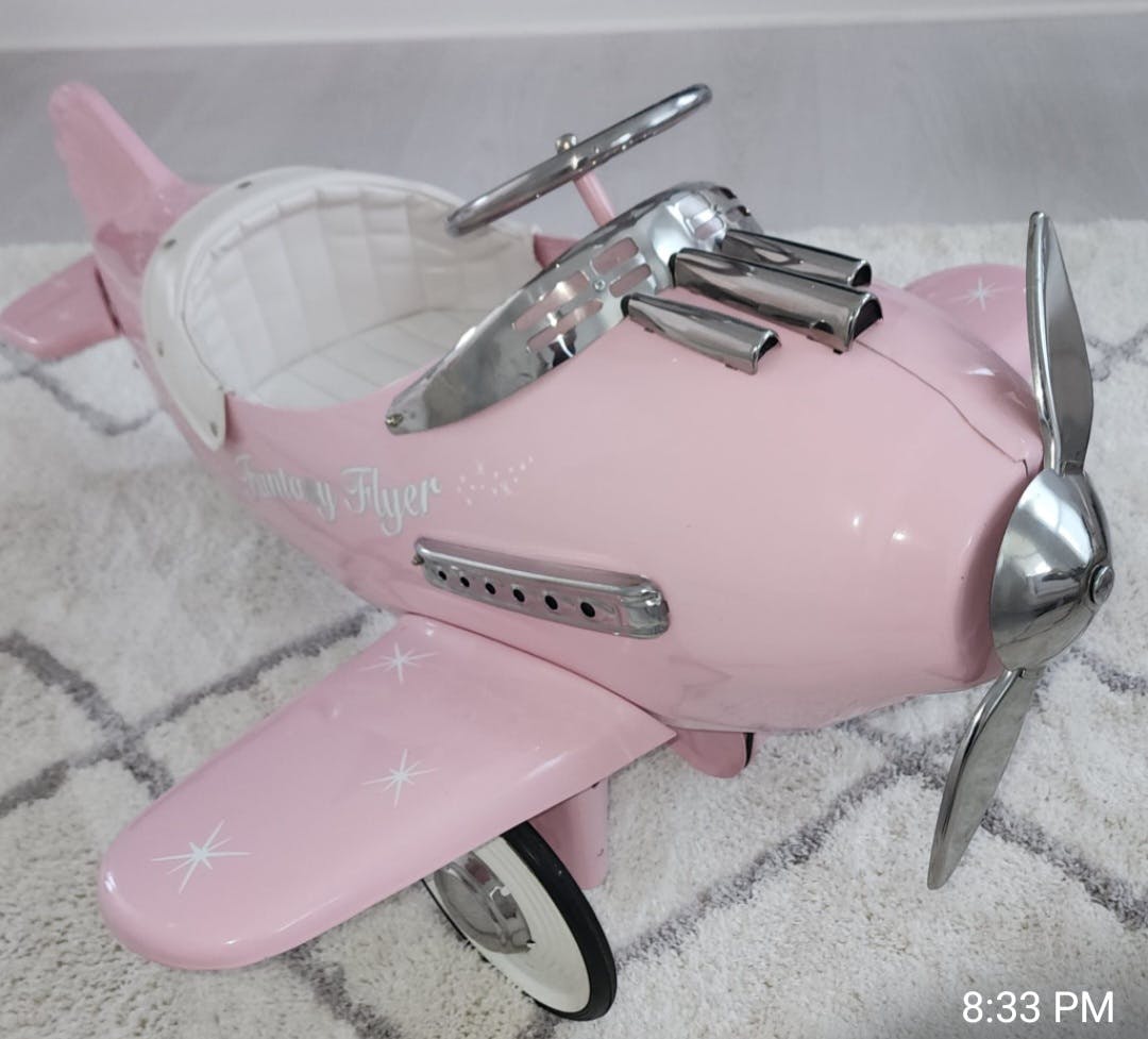 Pink toy airplane with a propeller and silver accents