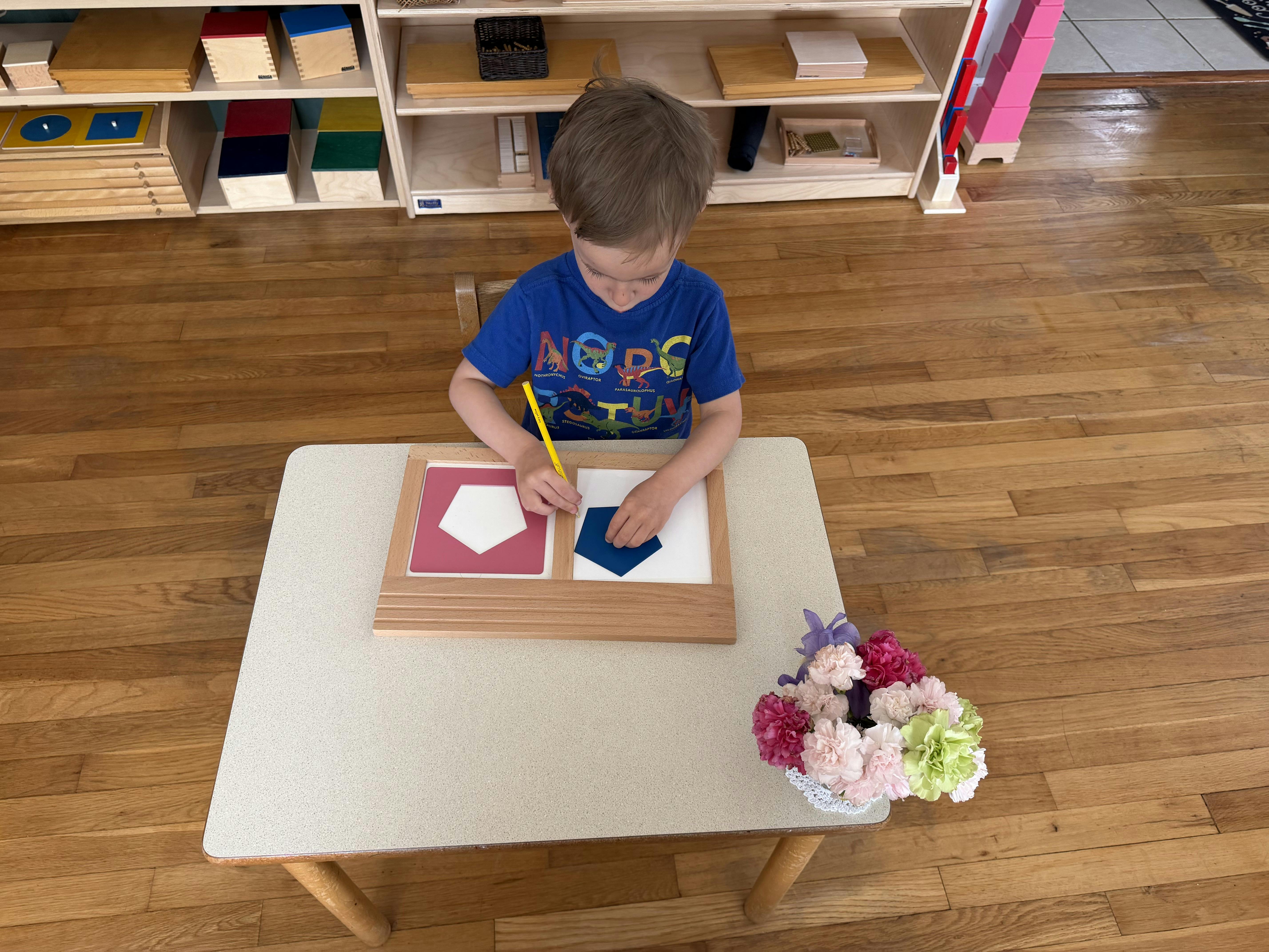 Child working with geometric shape inserts at a table