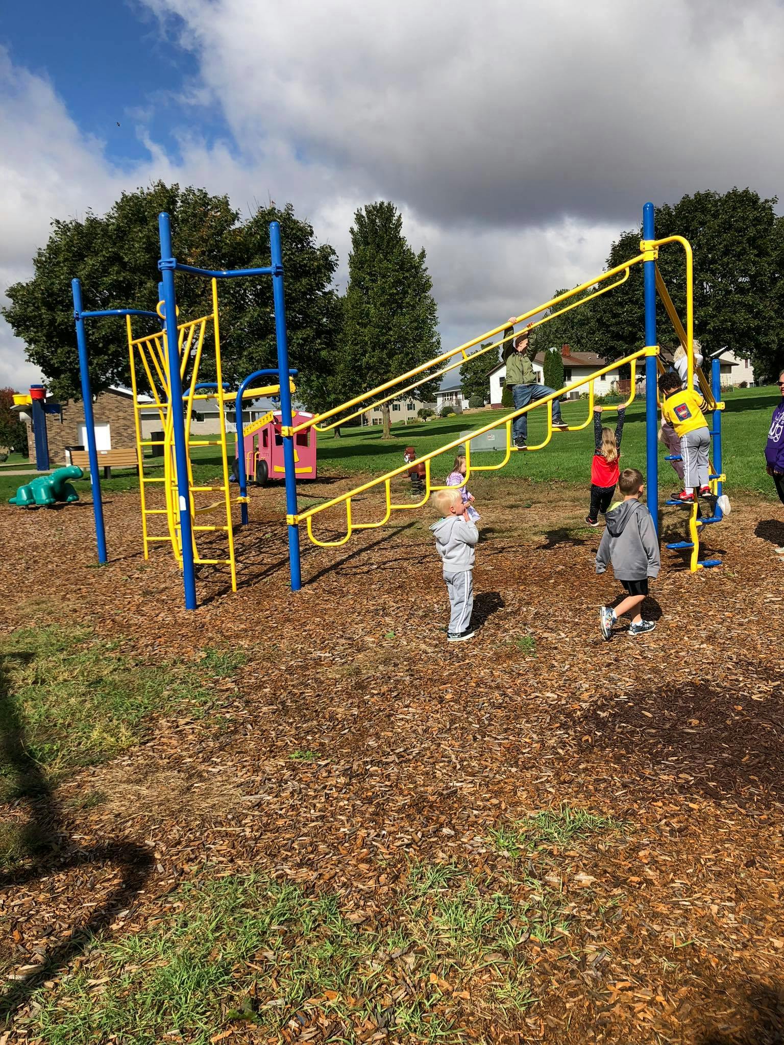 Children playing on a yellow and blue playground structure