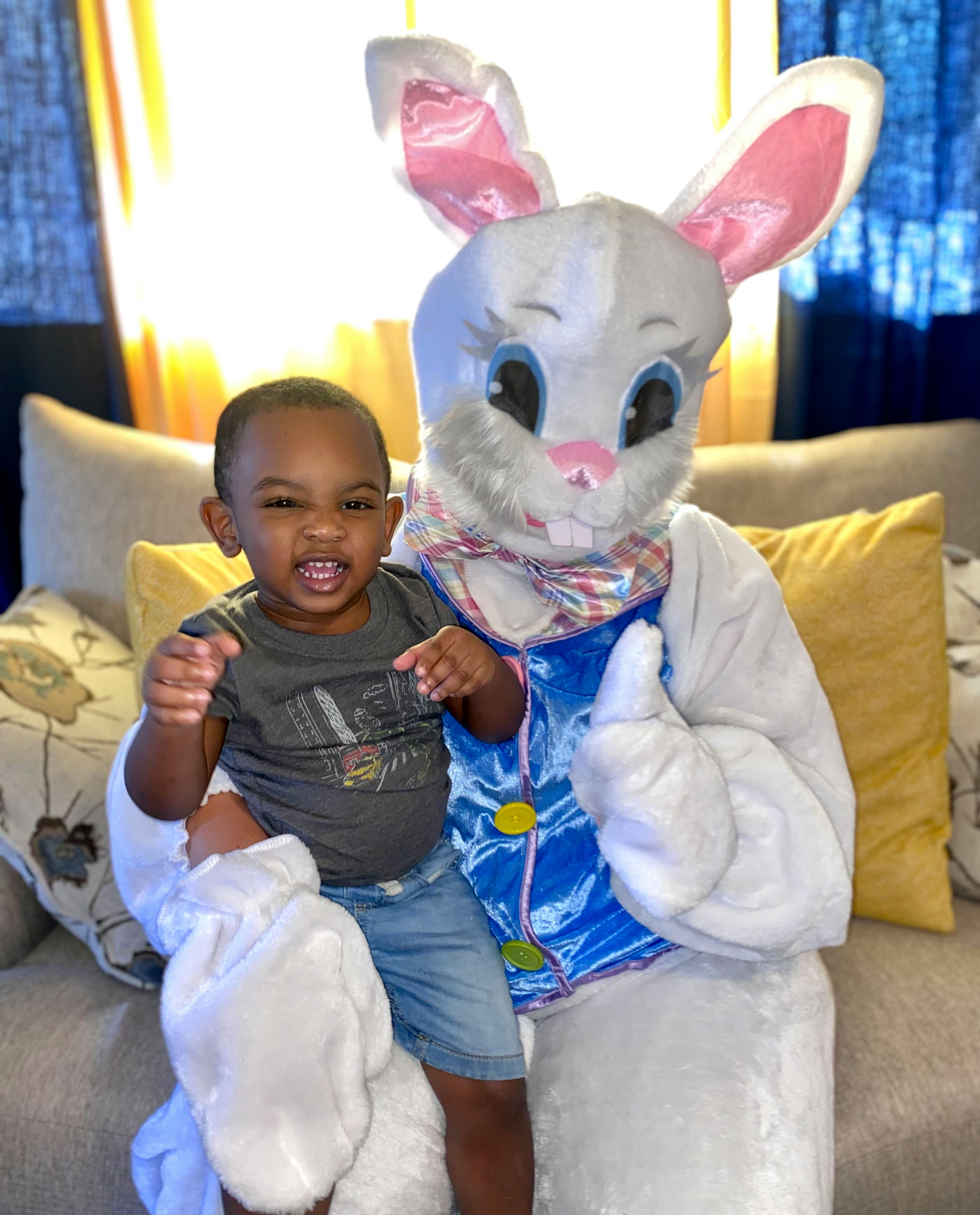 Child sitting with a person in a bunny costume
