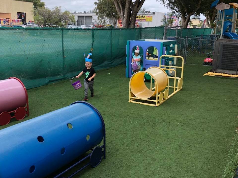 Child in bunny ears running with a basket on a playground