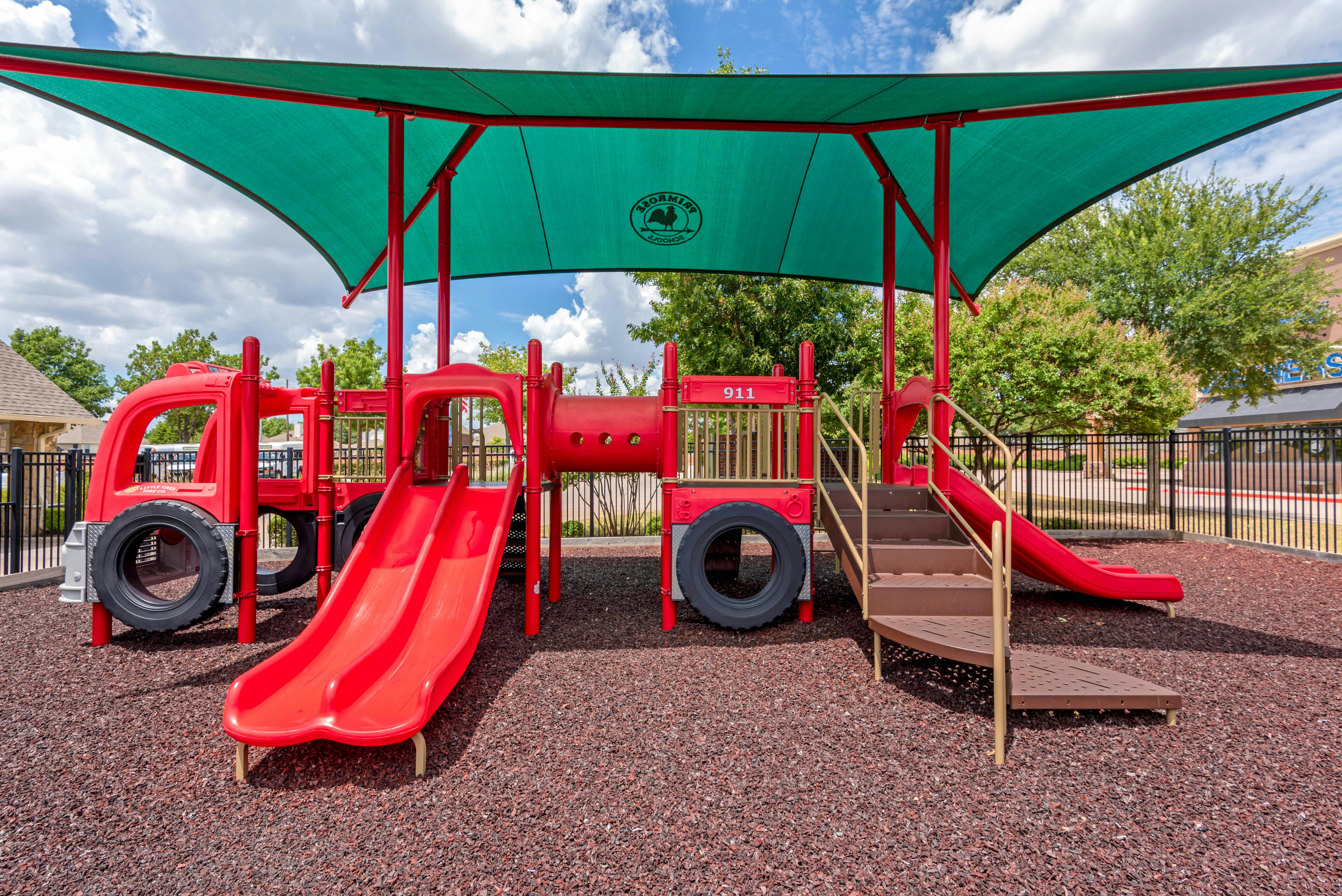Firetruck-themed playground with slides and climbing structures