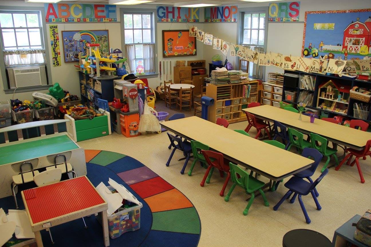 Classroom with tables, chairs, and colorful rug