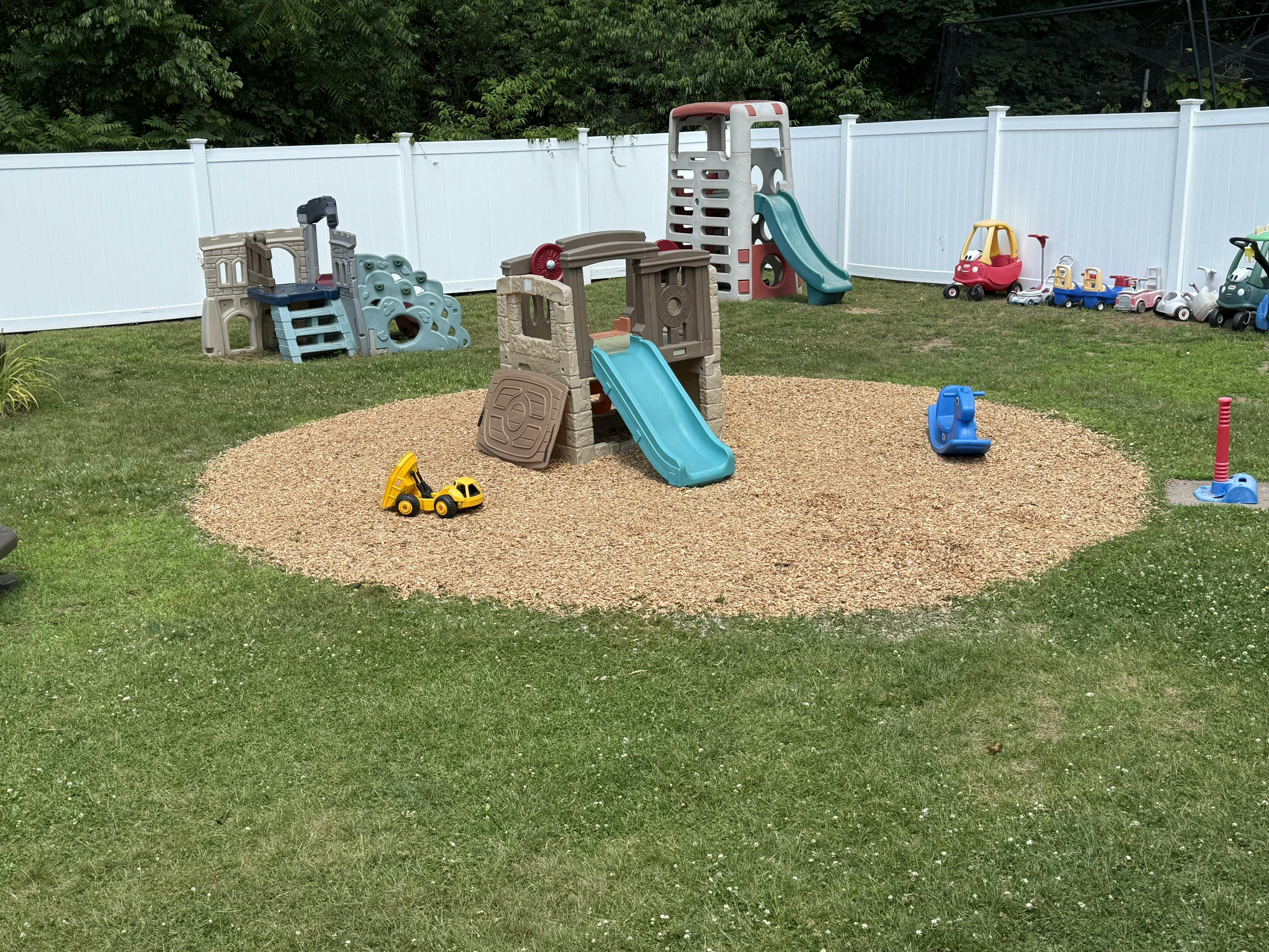 Outdoor playground with multiple slides and play structures on wood chips