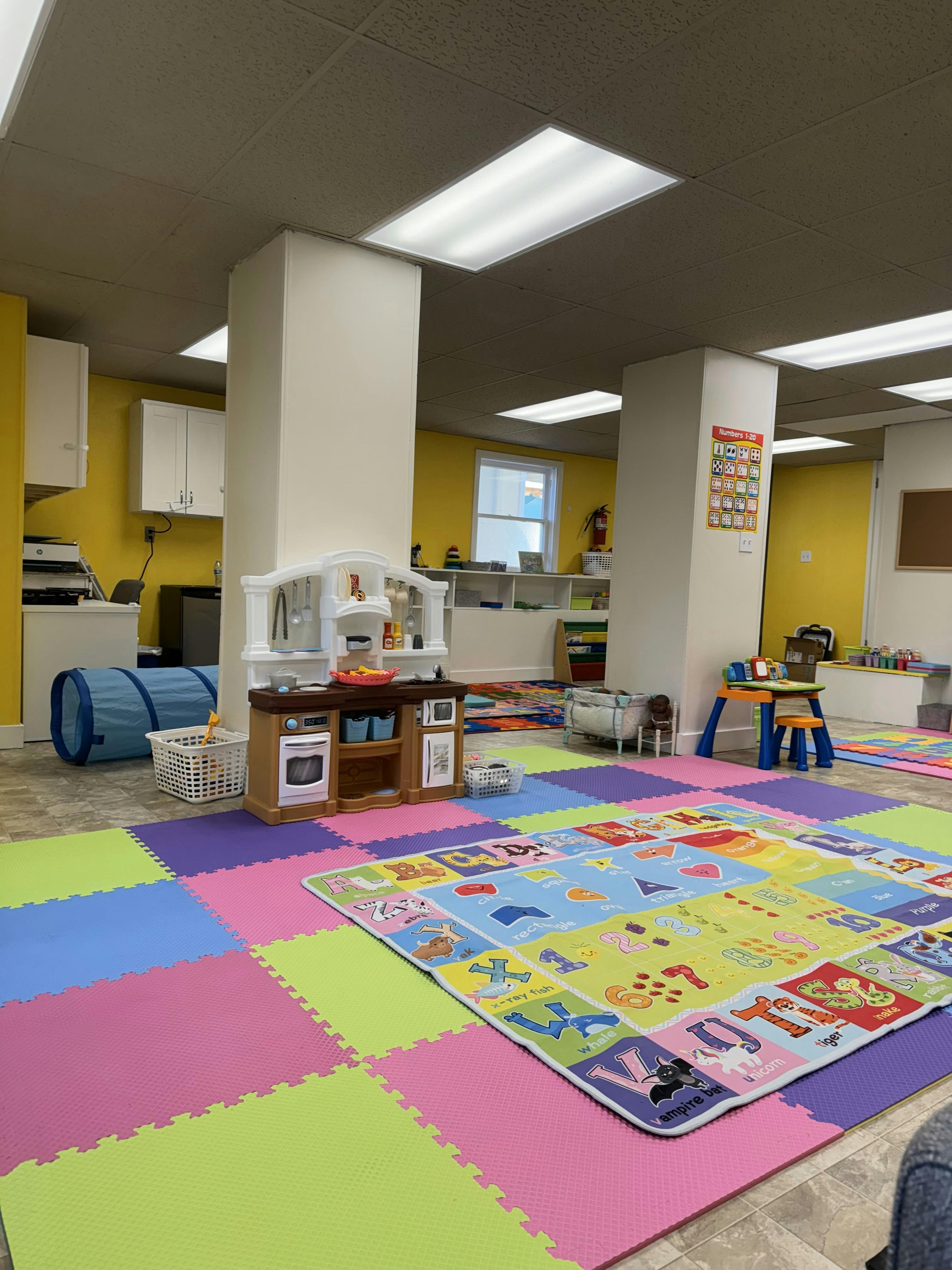 Playroom with colorful floor mats and children's play kitchen