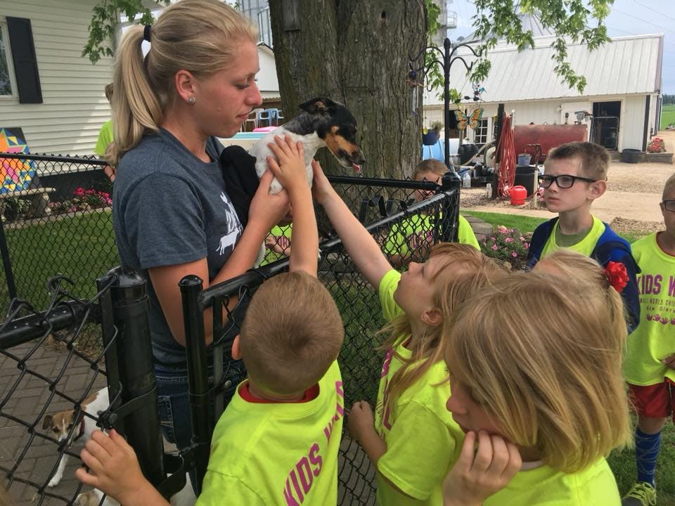 Person holding a small dog for children to pet