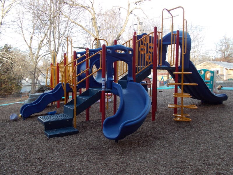 Playground structure with multiple slides and climbing elements