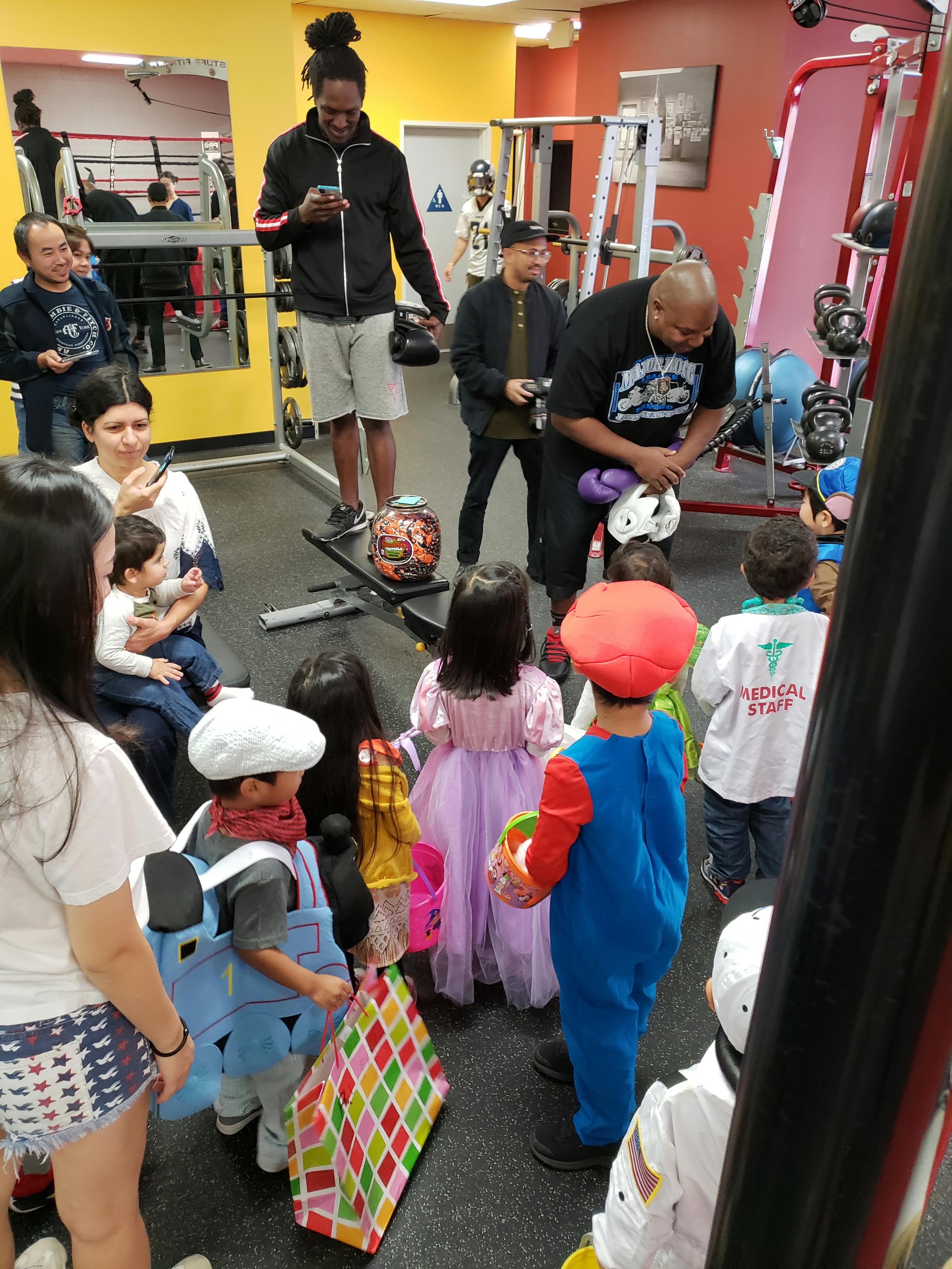 Adults and children in costumes in a gym