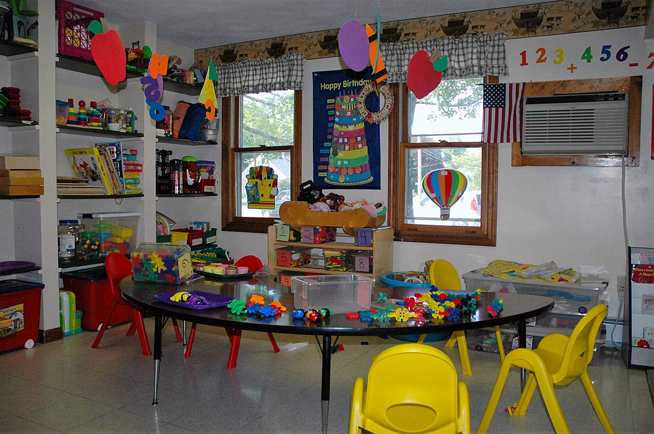 Playroom with a large table, small chairs, and toys