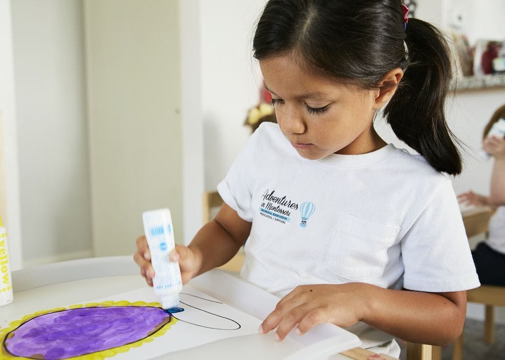 Child applying glue to a drawing