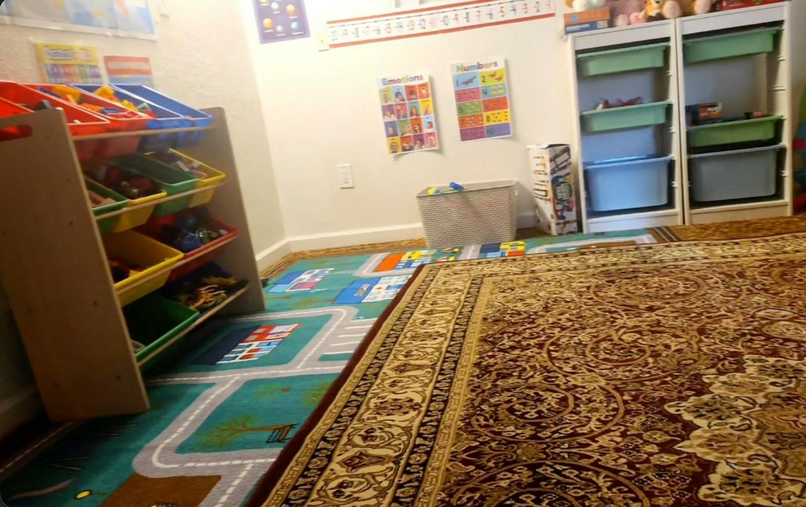 Playroom with colorful toy storage bins and a rug featuring a town map