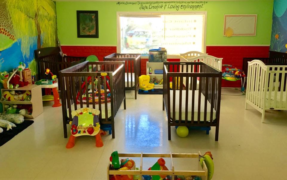 Multiple cribs in a brightly colored room with toys