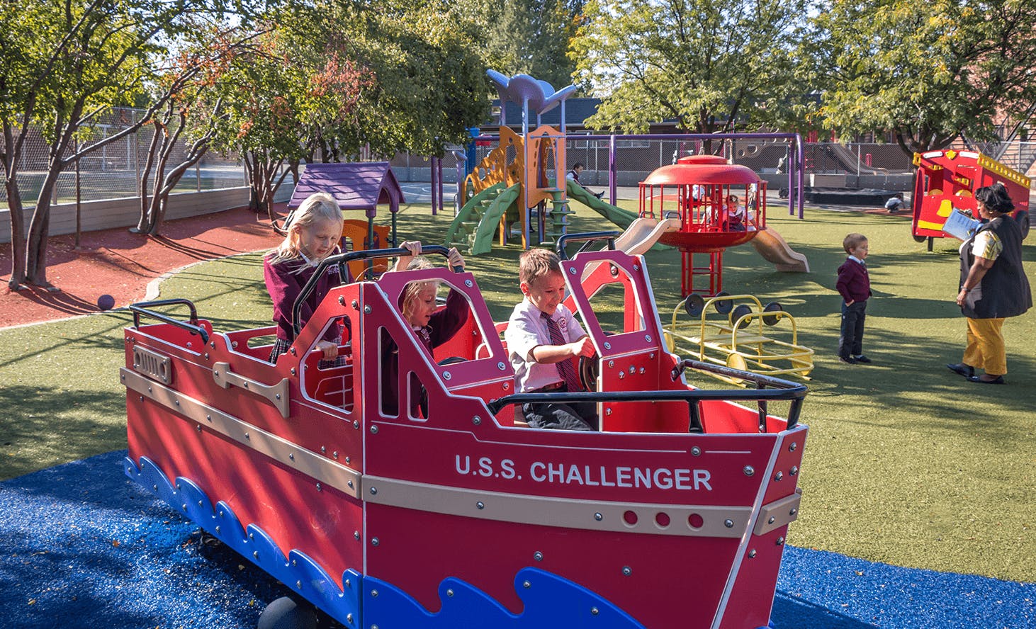Children playing on a red boat structure on a playground