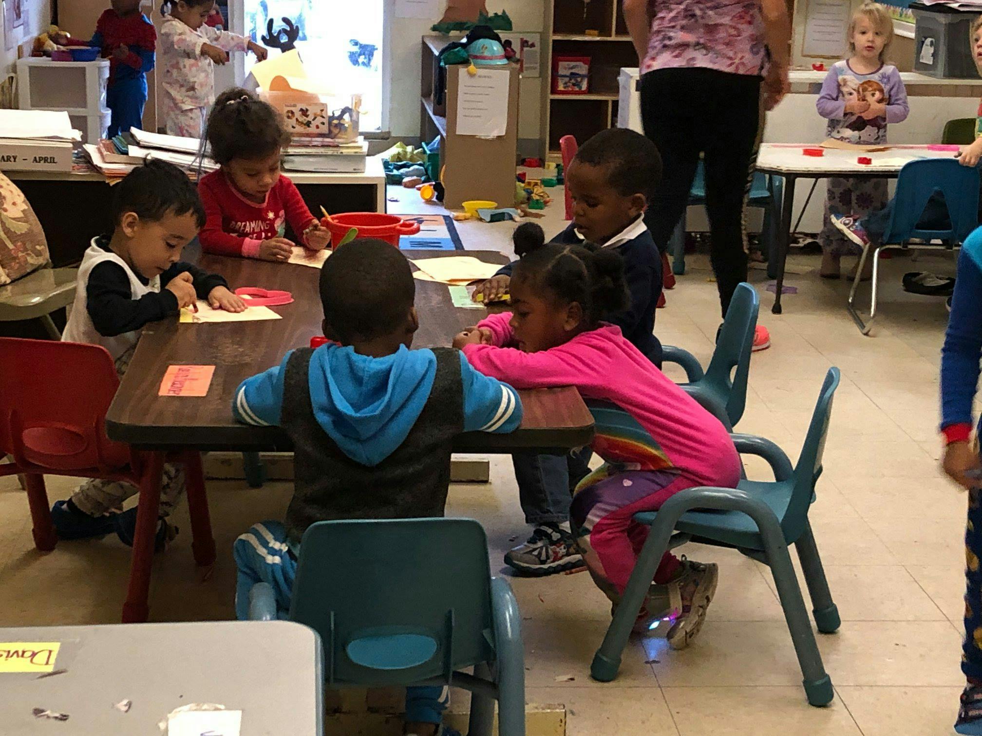Children sitting at a table in a classroom
