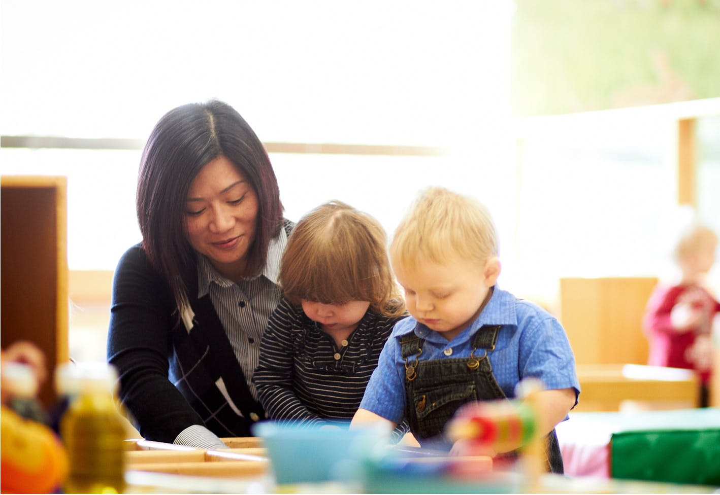 Person with two children looking down at a table
