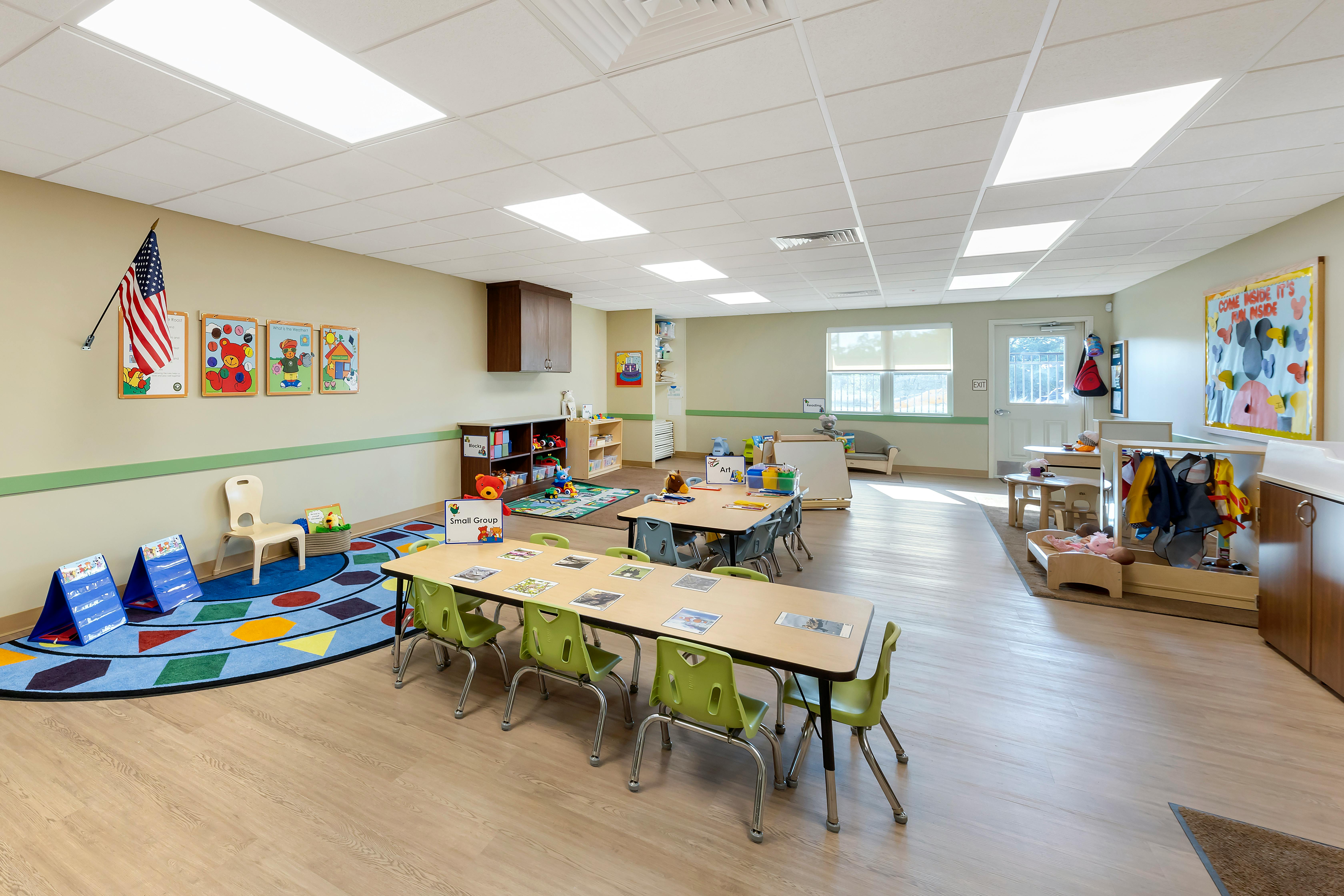 Classroom with tables, chairs, educational posters, and play areas