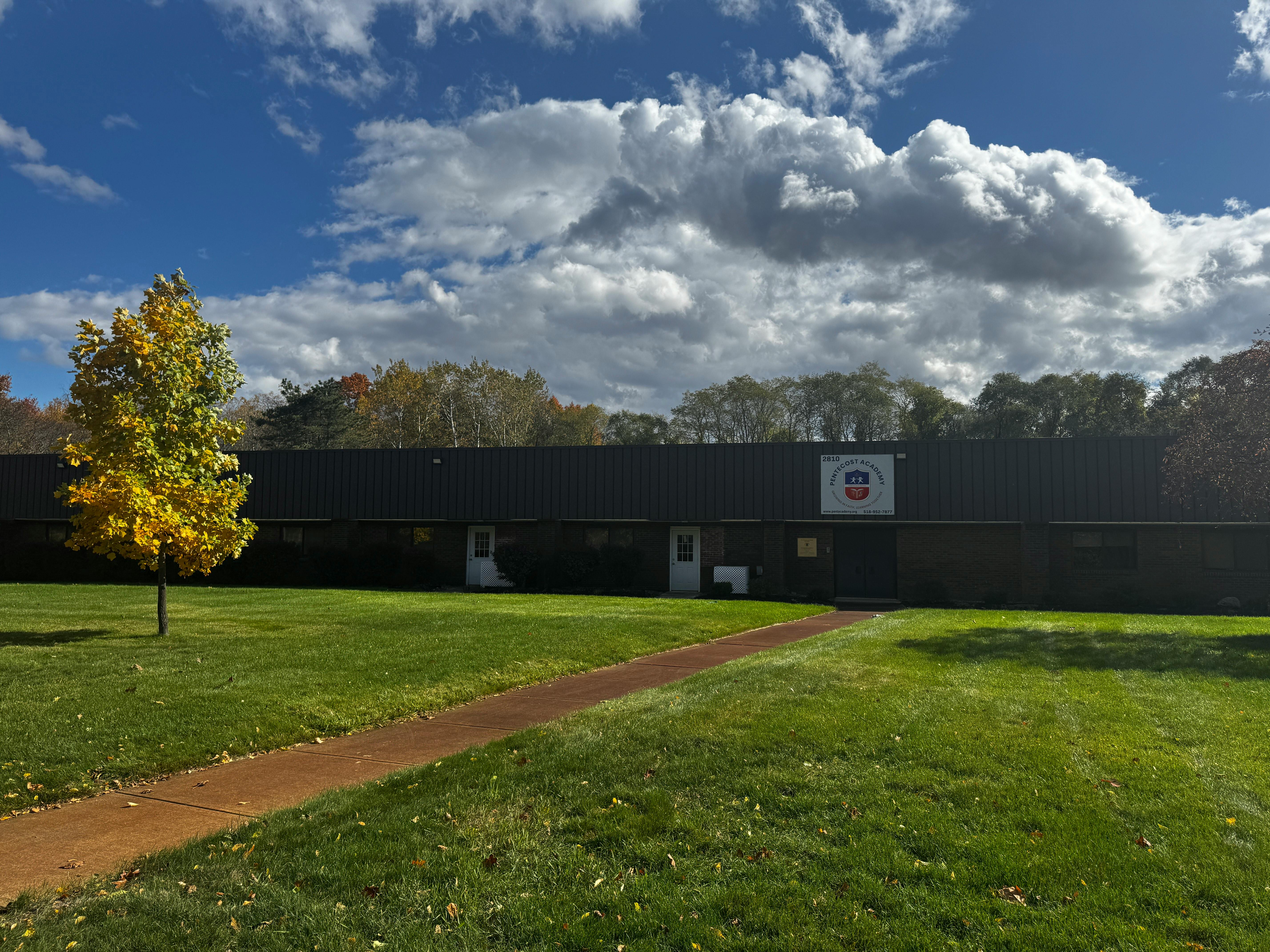 Building with a path leading to it, a tree in the foreground