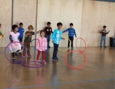 Children playing with hula hoops indoors
