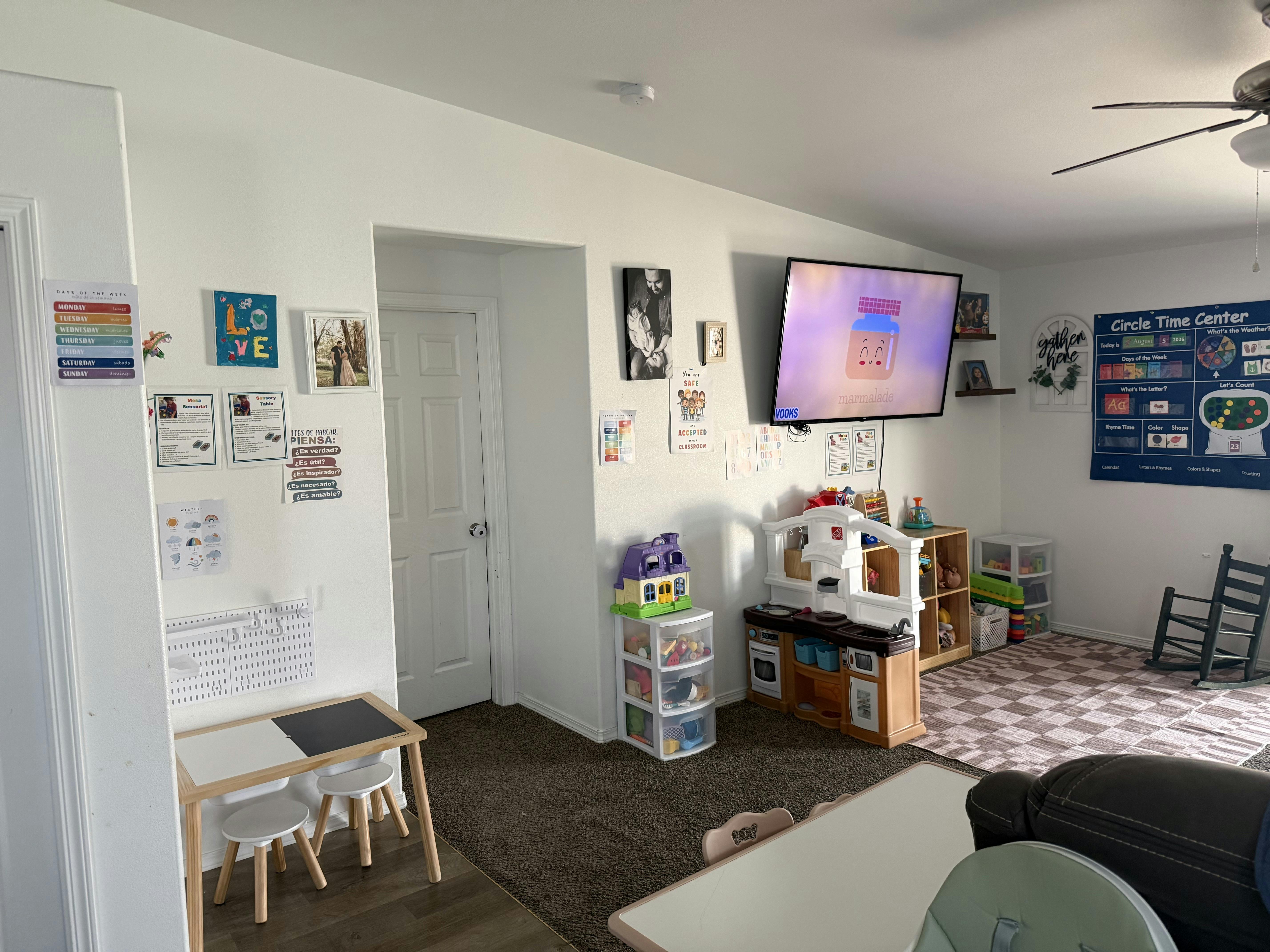 Playroom featuring educational posters, a toy kitchen, and small furniture