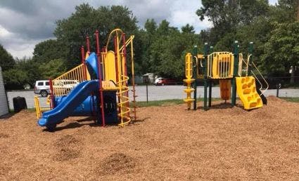 Playground with blue and yellow slides and climbing structures