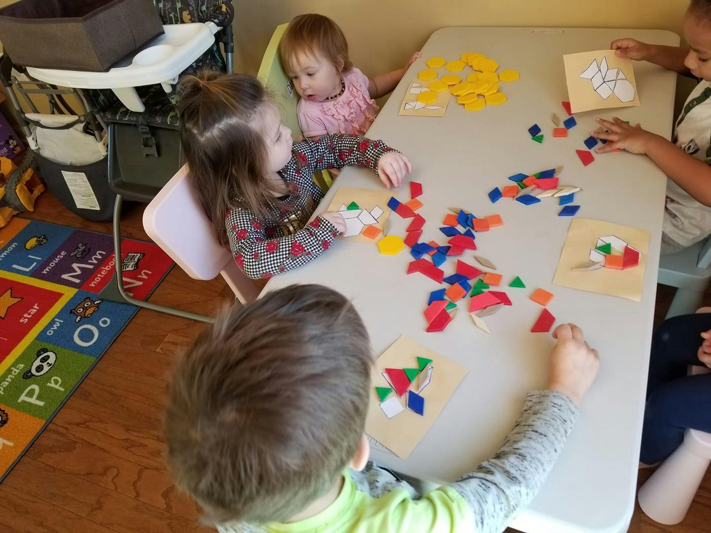 Children playing with colorful geometric shapes at a table