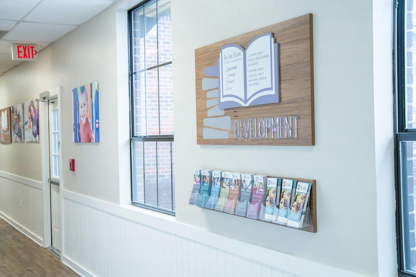 Sign on wall reading The Four Pillars Development with brochure display below
