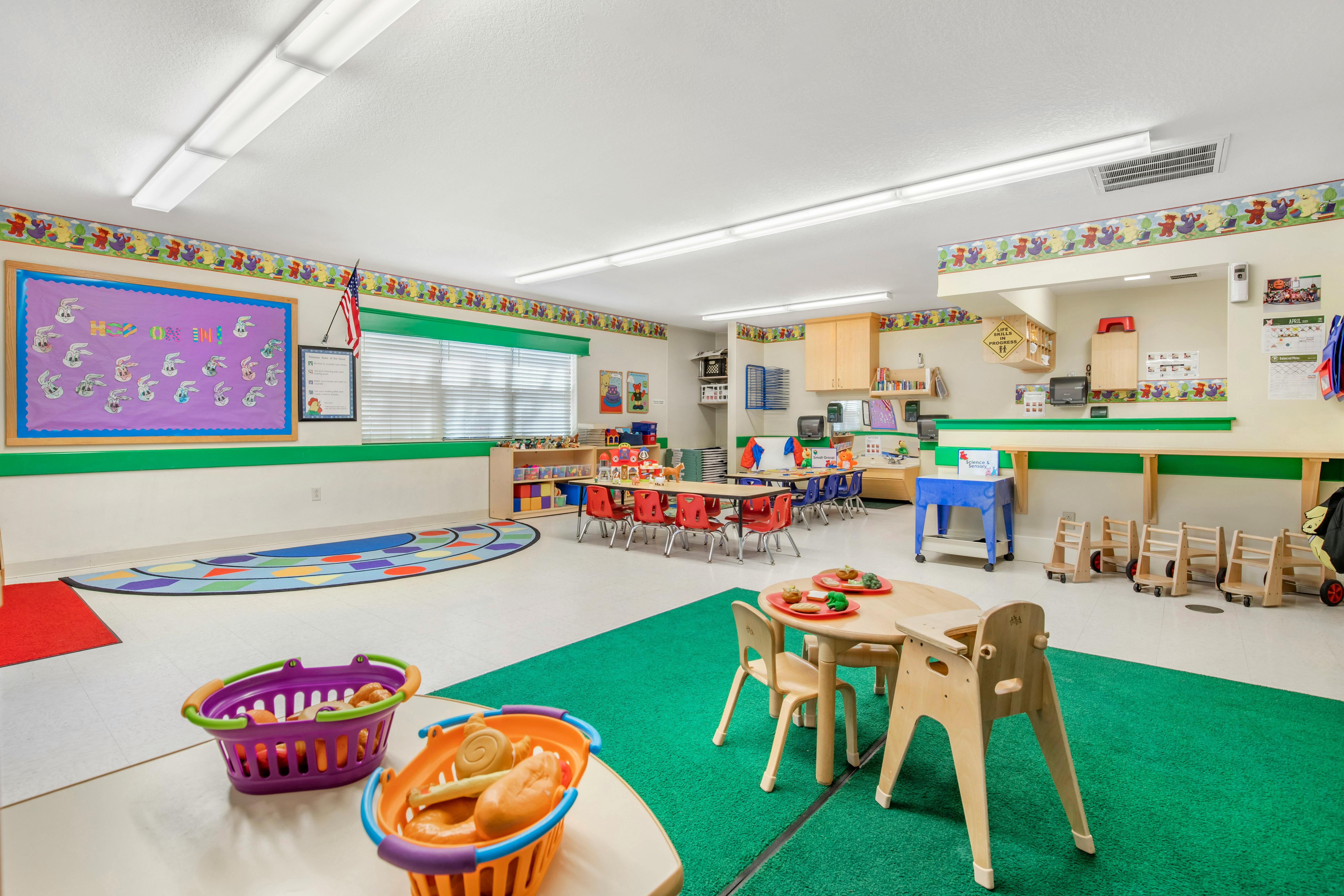 A colorful classroom with small tables and chairs for children