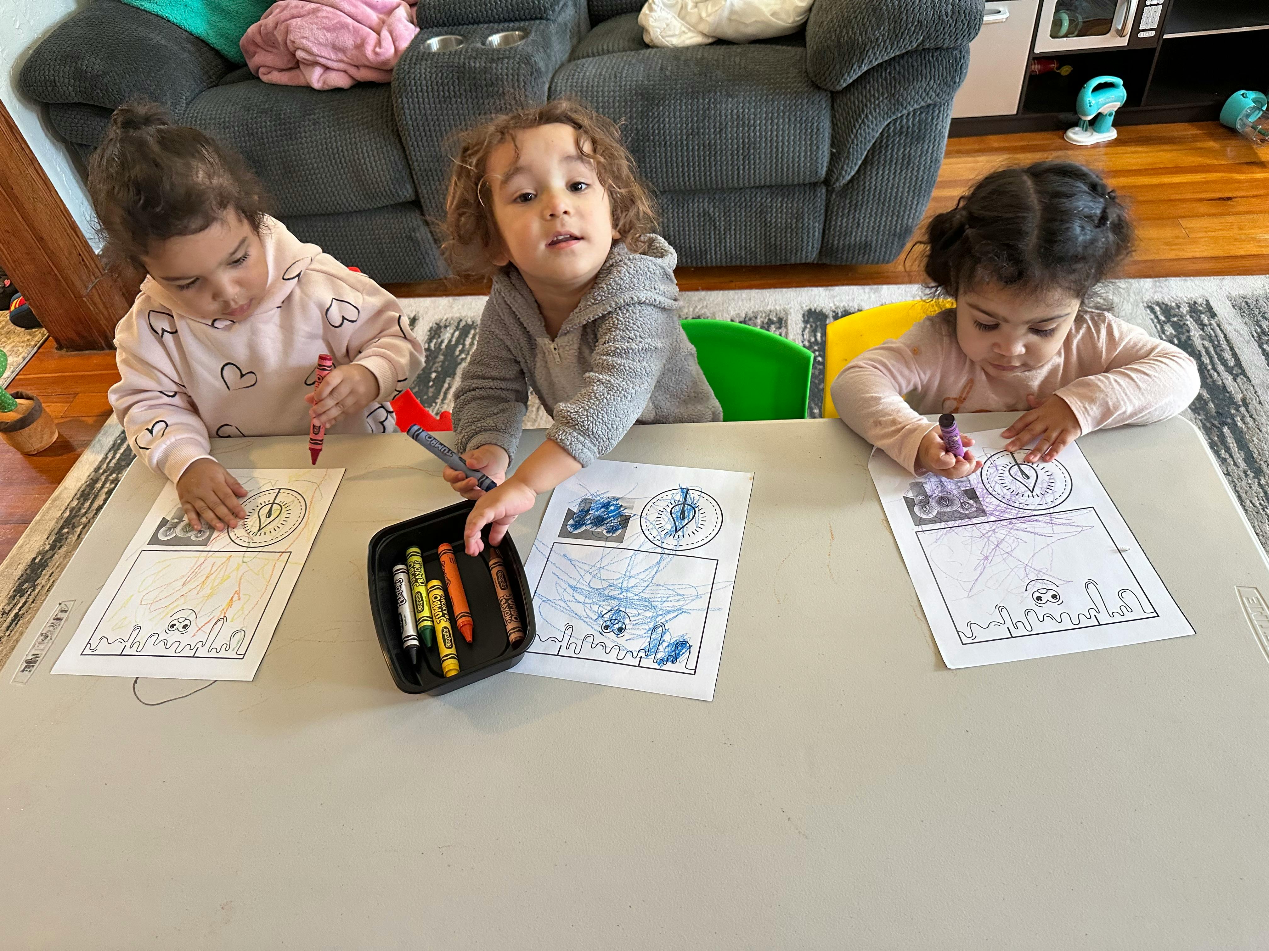 Three children coloring at a table