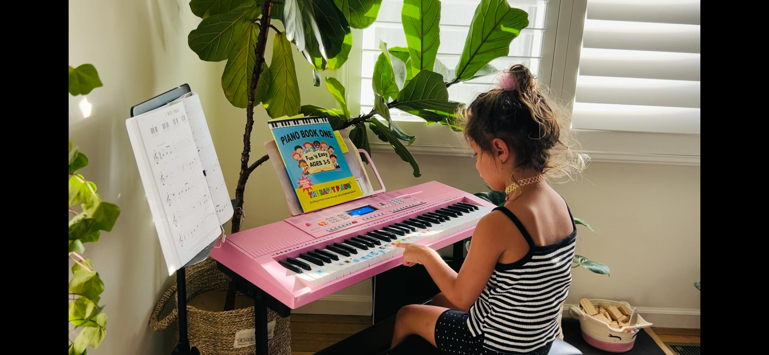Child playing a pink keyboard