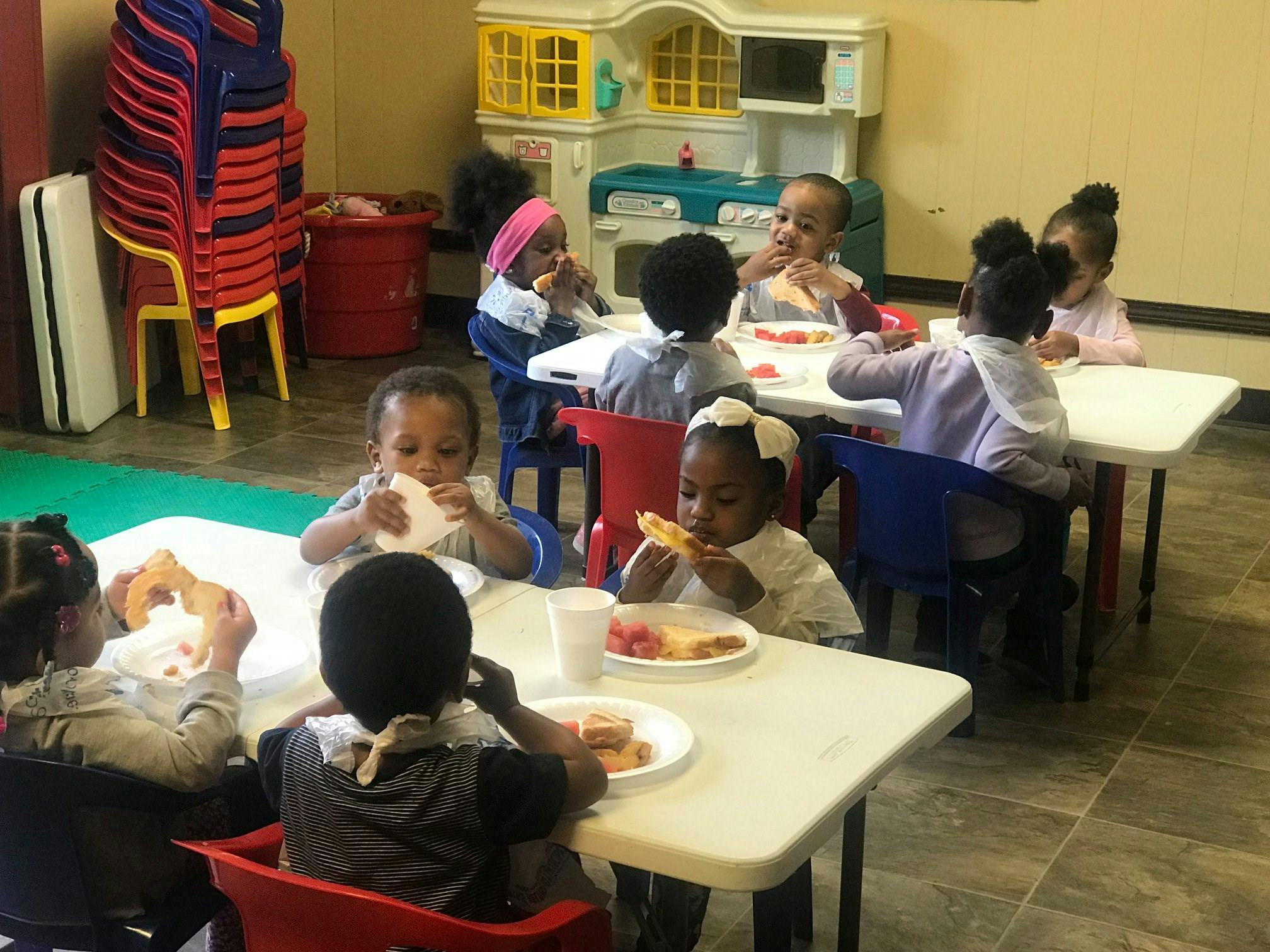 Children eating at tables in a classroom