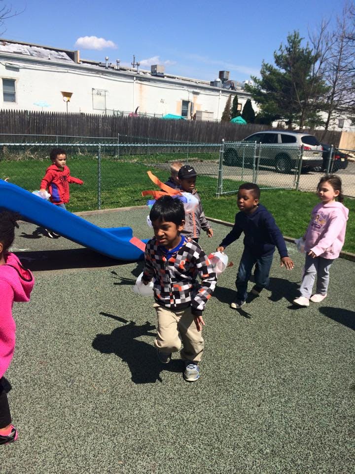 Children playing on a playground with a blue slide