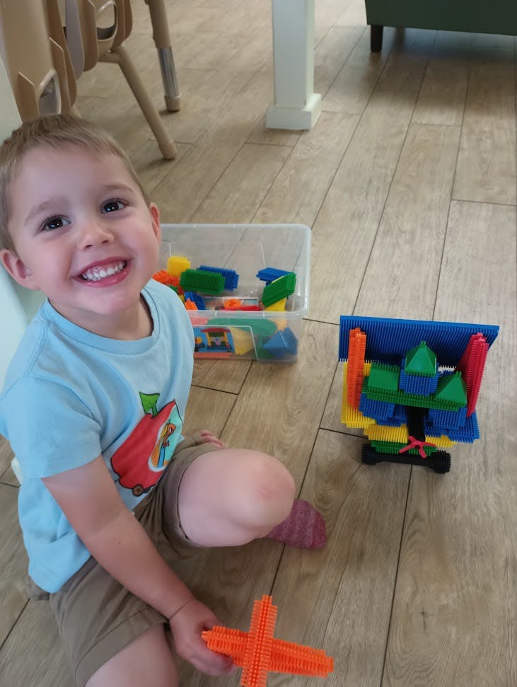 Child on floor playing with colorful building blocks
