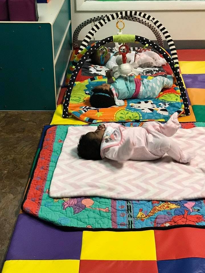 Two babies sleeping on colorful mats
