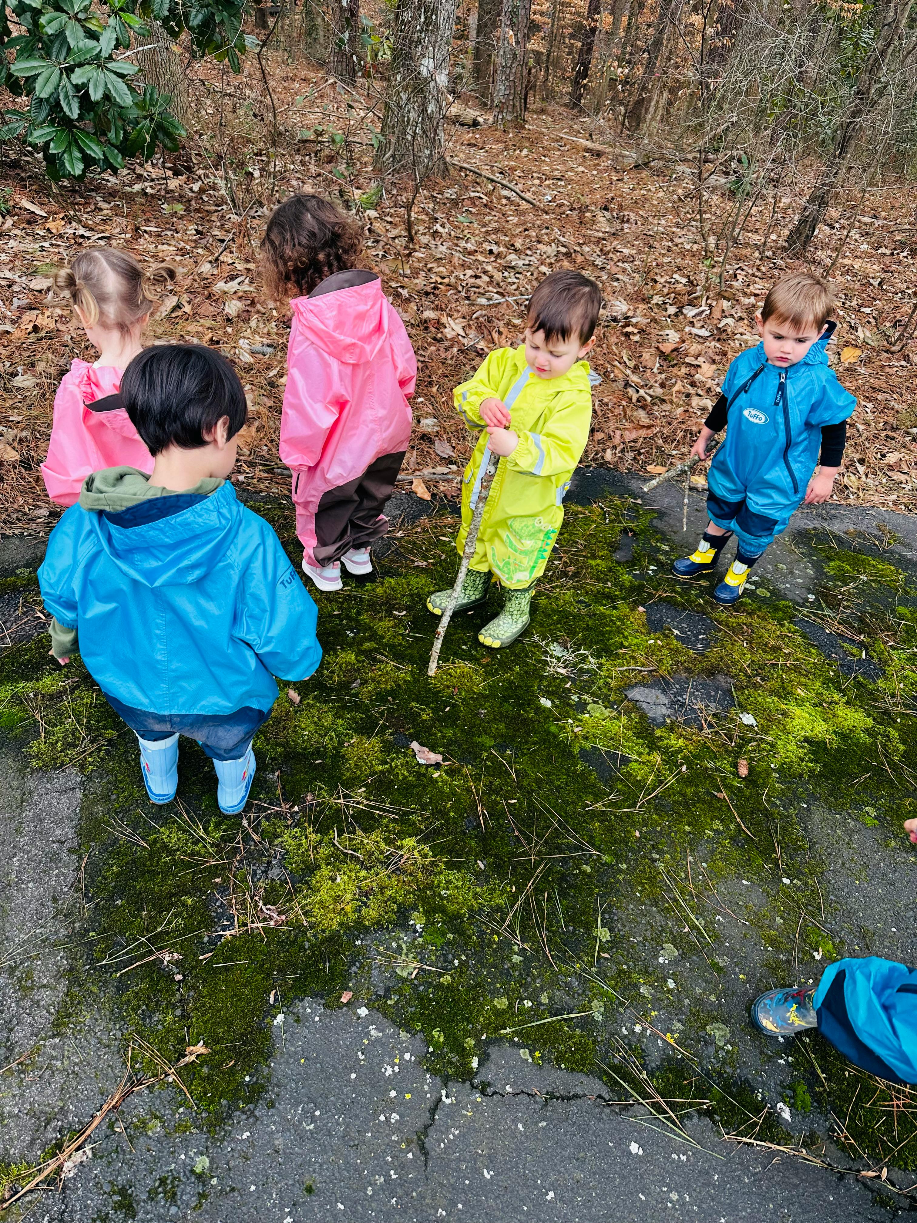 Children in rain gear playing outdoors